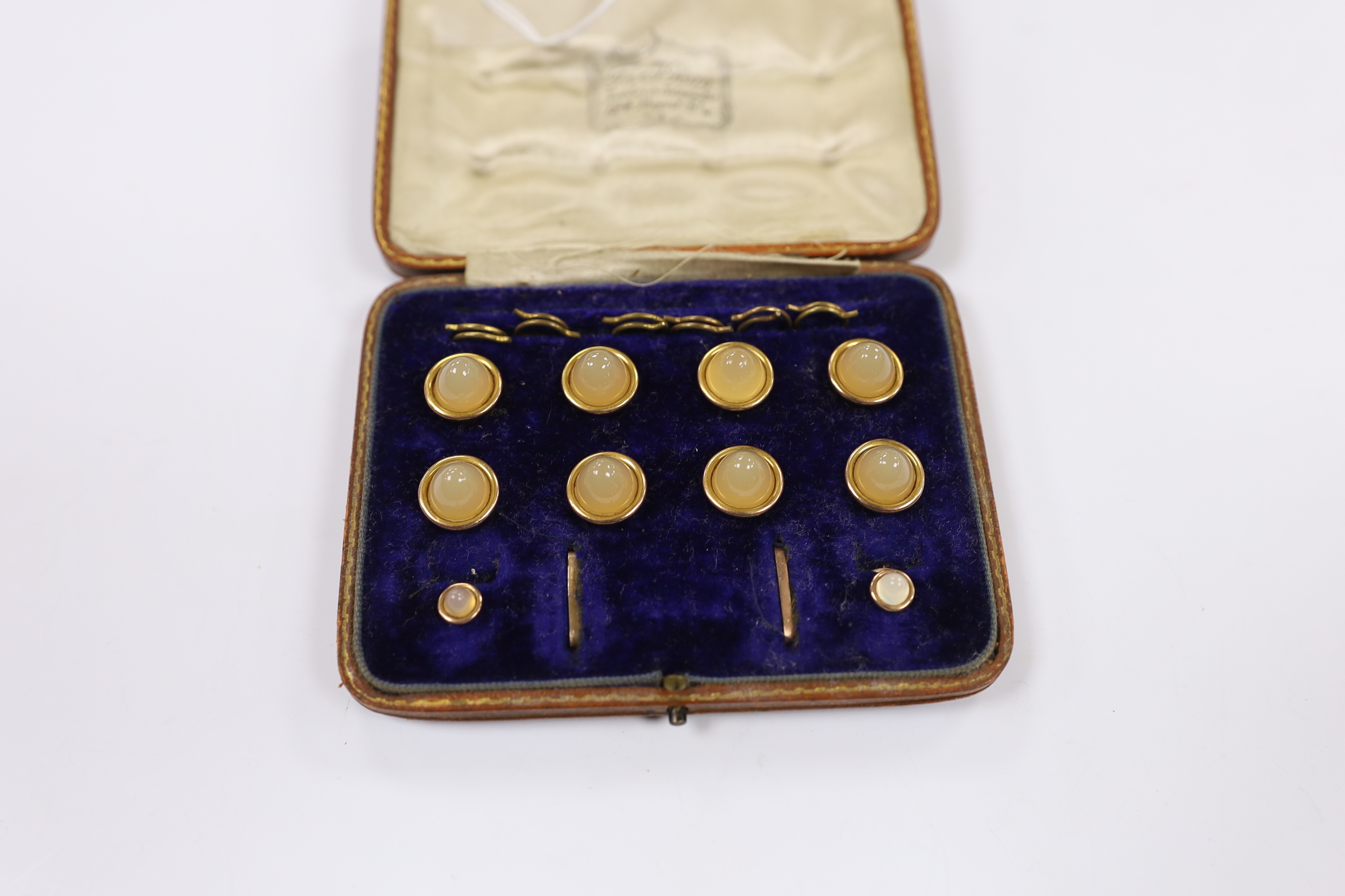 An early 20th century 9ct and chalcedony set ten piece dree stud set, in fitted gilt tooled leather case, gross weight 19.9 grams.